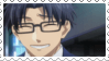 Man with short blue hair and glasses smiling.
